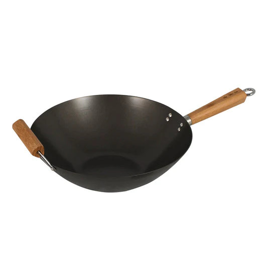 Chef stir-frying vegetables in a round-bottomed wok over a high-flame burner