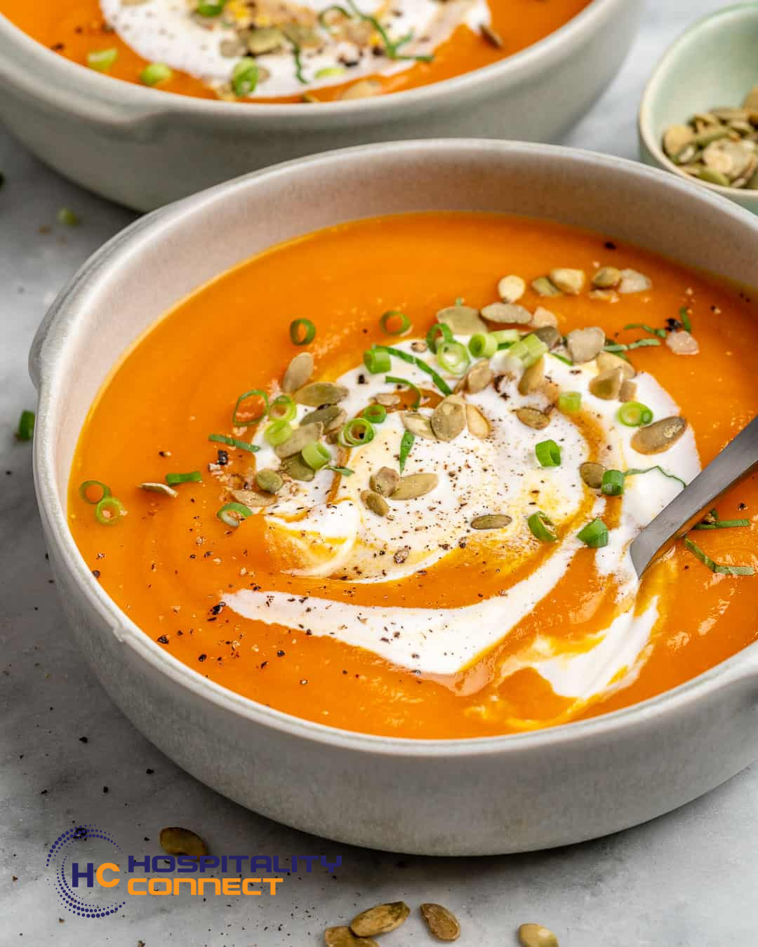 Large pot of creamy pumpkin soup being prepared in a commercial kitchen for bulk service