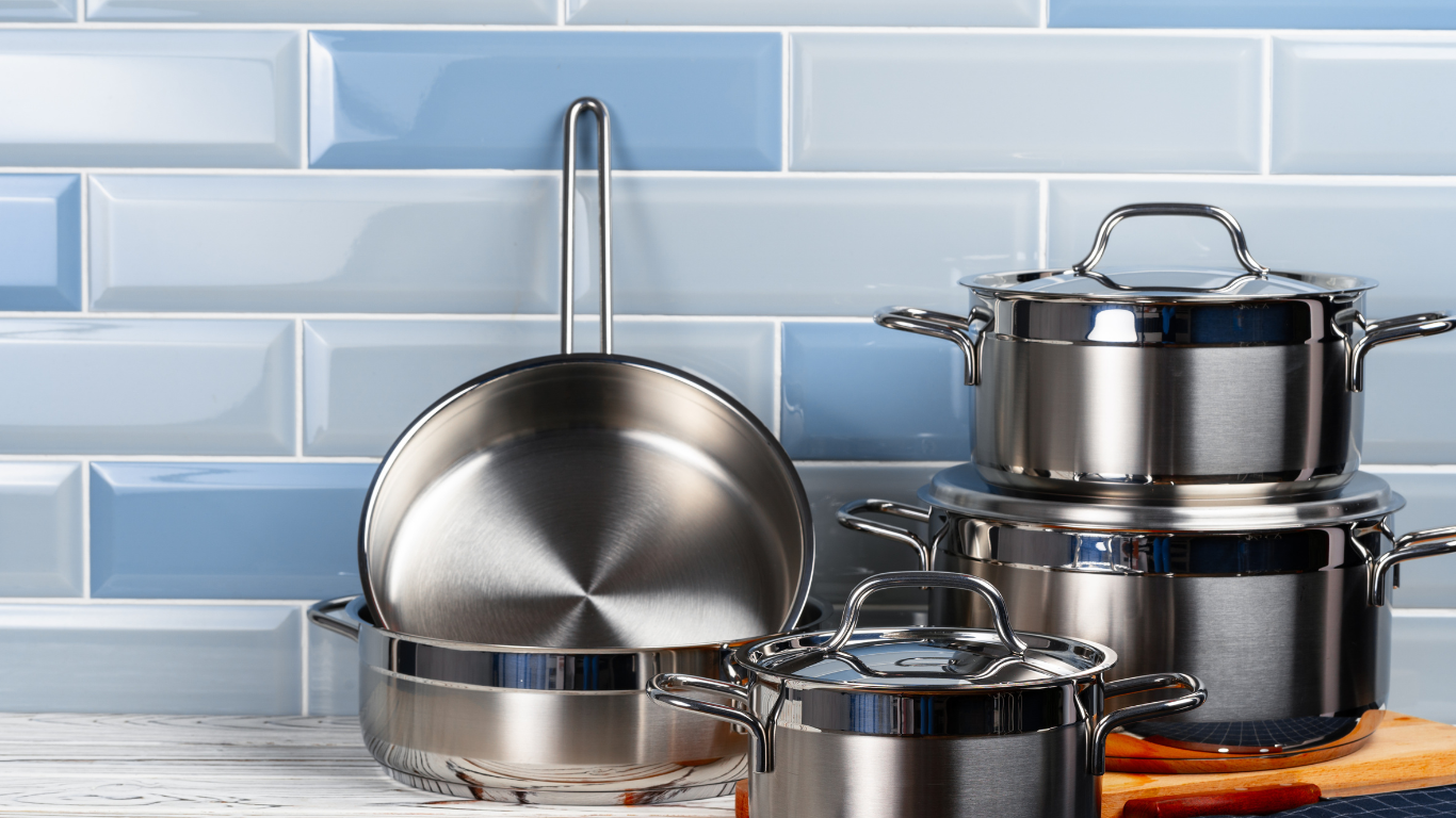 Stainless steel and aluminium cookware pieces compared on a kitchen bench