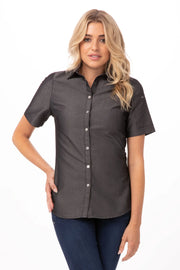 Chef Works Detroit women's denim shirt displayed on a model, featuring classic blue denim, button-down front, and long sleeves.